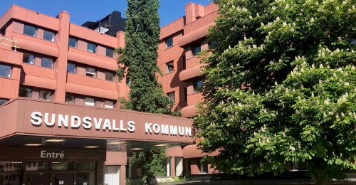 Sundsvalls kommunhus med grönskade sommar och över entrén till receptionen står det utskrivet Sundsvalls kommun.